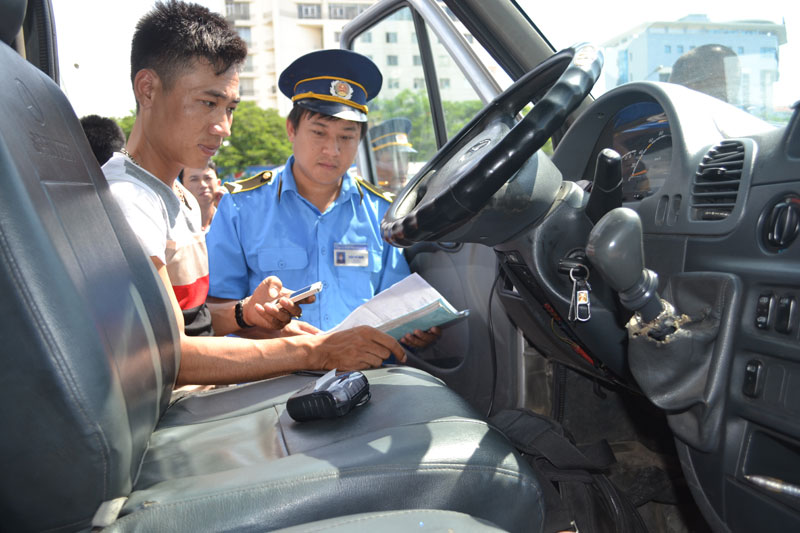 Lực lượng Thanh tra giao thông kiểm tra thiết bị giám sát hành trình của xe kinh doanh vận tải. Ảnh: Tuấn Lương